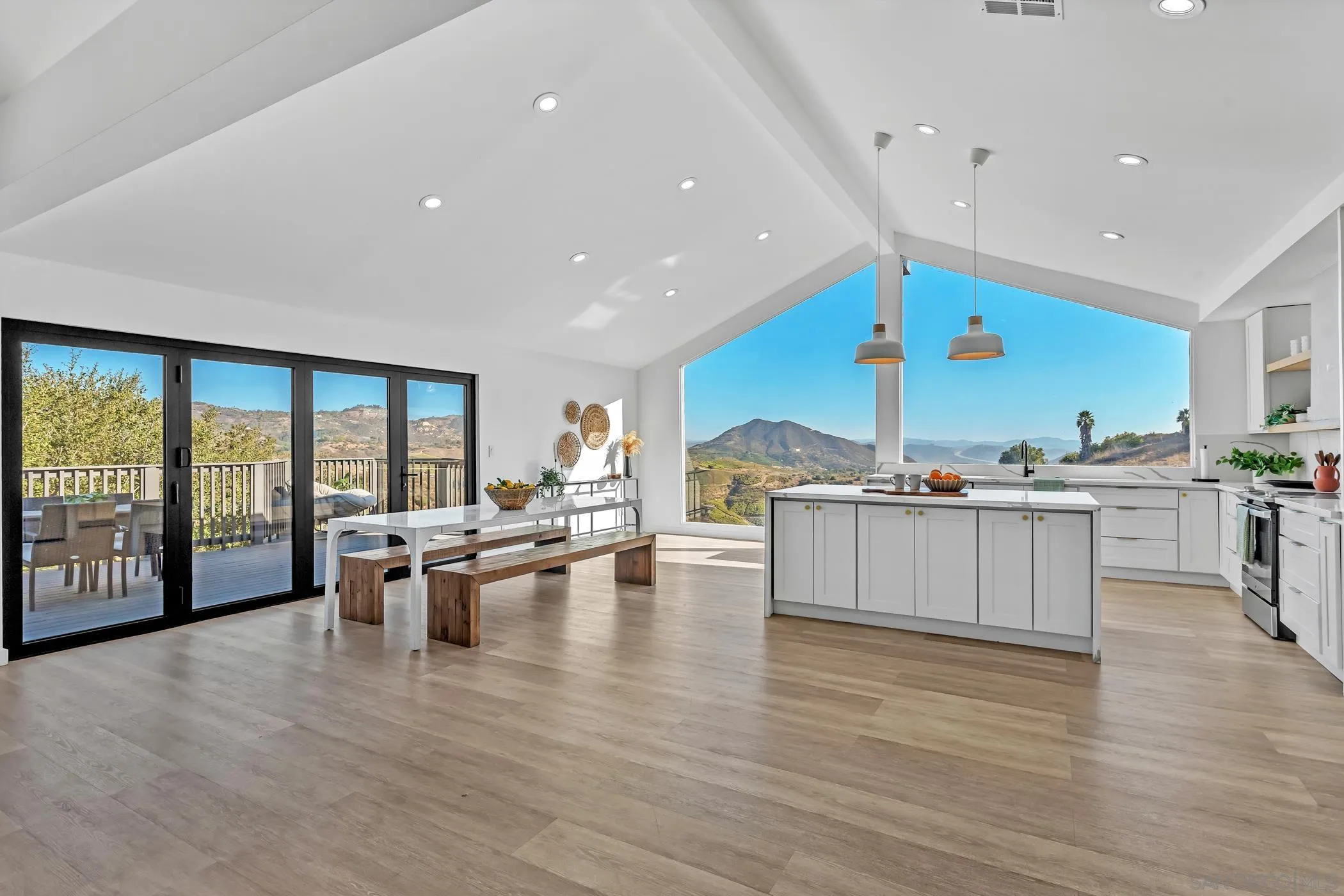 1029 Rainbow Valley Court Fallbrook, CA 92028 - Photo 26 of 75 a kitchen with stainless steel appliances granite countertop a stove top oven a dining table and chairs with wooden floor