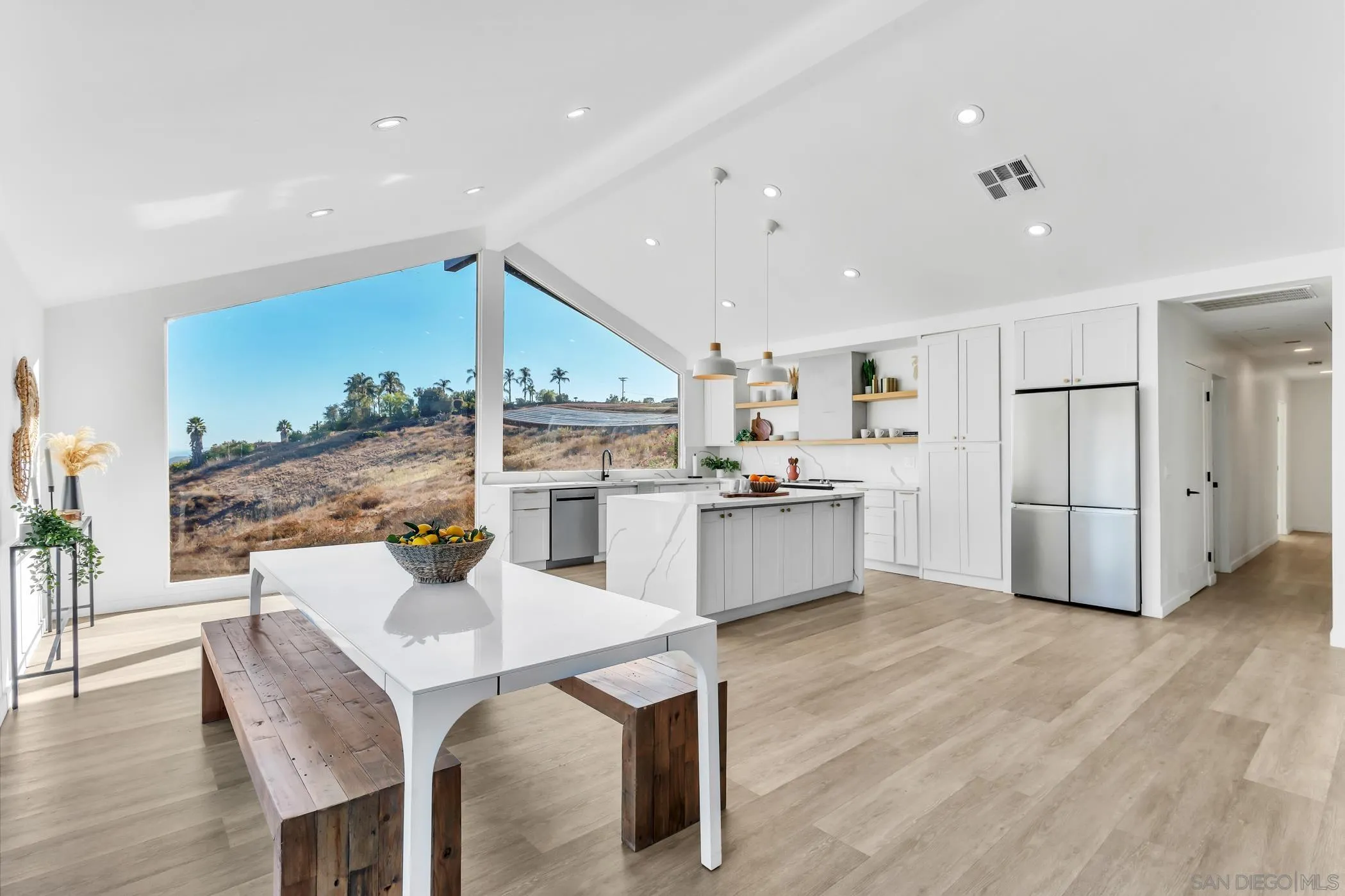 1029 Rainbow Valley Court Fallbrook, CA 92028 - Photo 31 of 75 a kitchen with stainless steel appliances kitchen island granite countertop a table chairs and a refrigerator