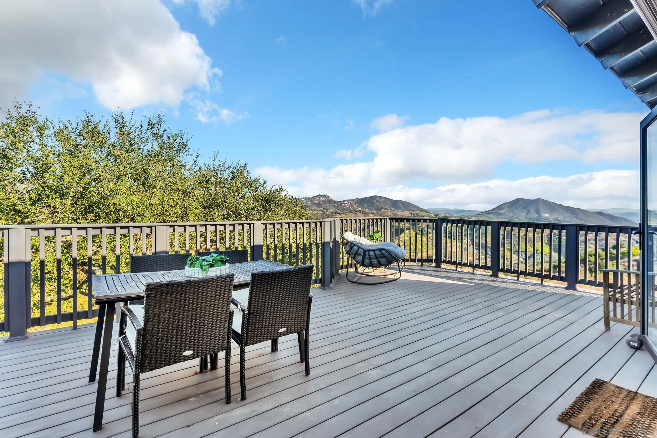 1029 Rainbow Valley Court Fallbrook, CA 92028 - Photo 54 of 75 a view of a roof deck with table and chairs a barbeque with wooden floor and fence
