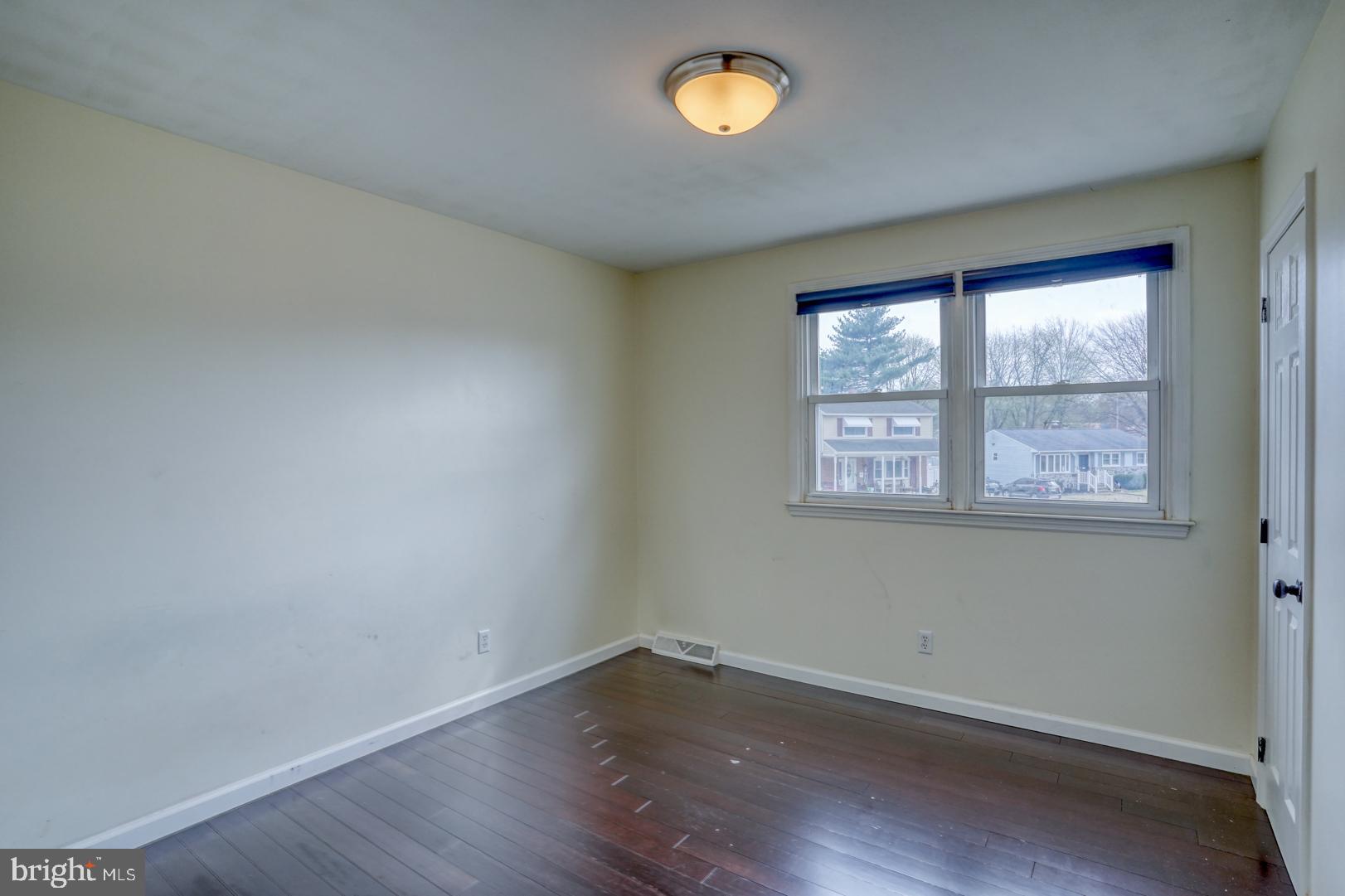 1245 Harrison Drive Dover, DE 19901 - Photo 11 of 47 an empty room with wooden floor and windows