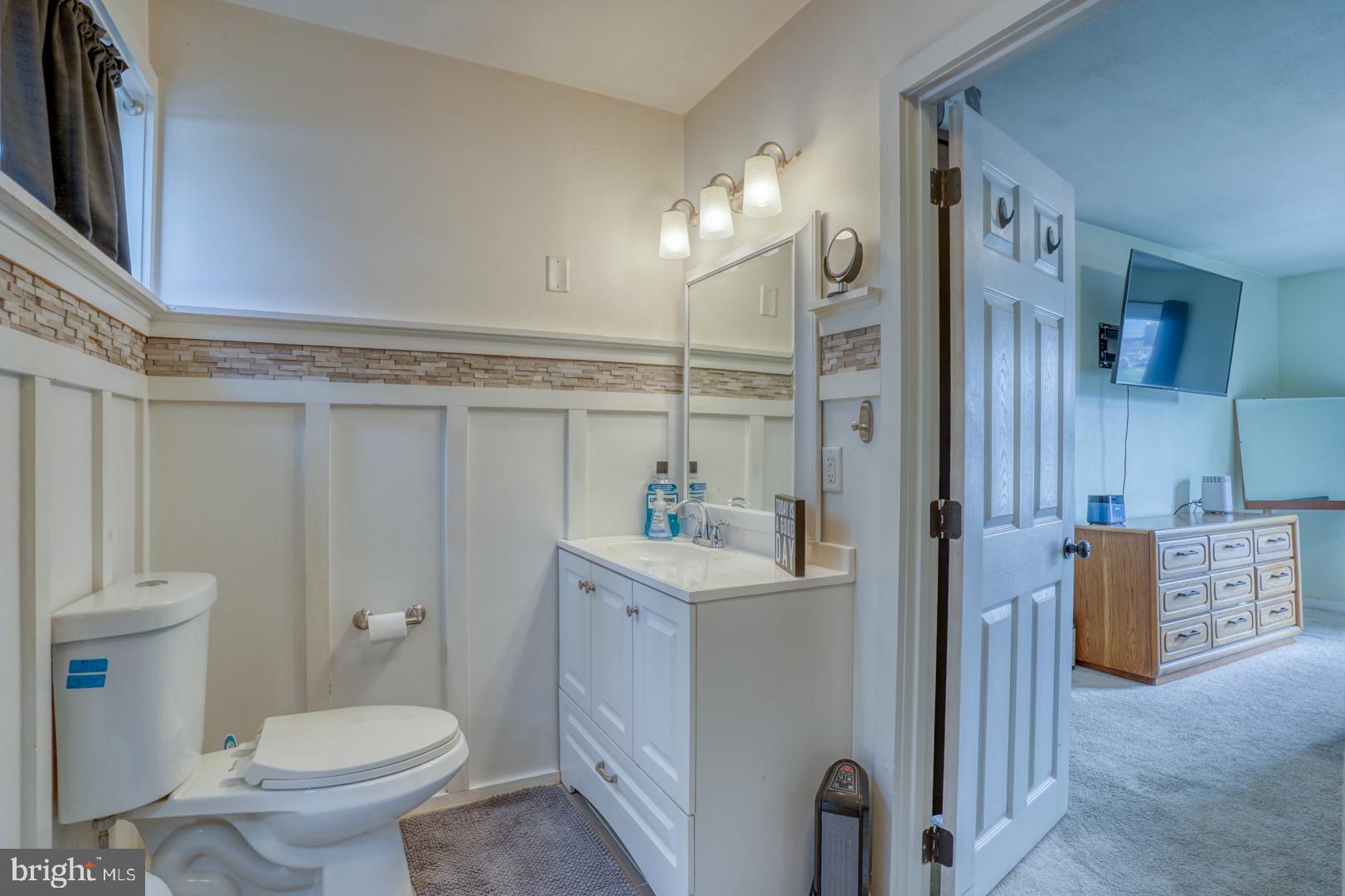 1245 Harrison Drive Dover, DE 19901 - Photo 24 of 47 a bathroom with a toilet a sink and a mirror