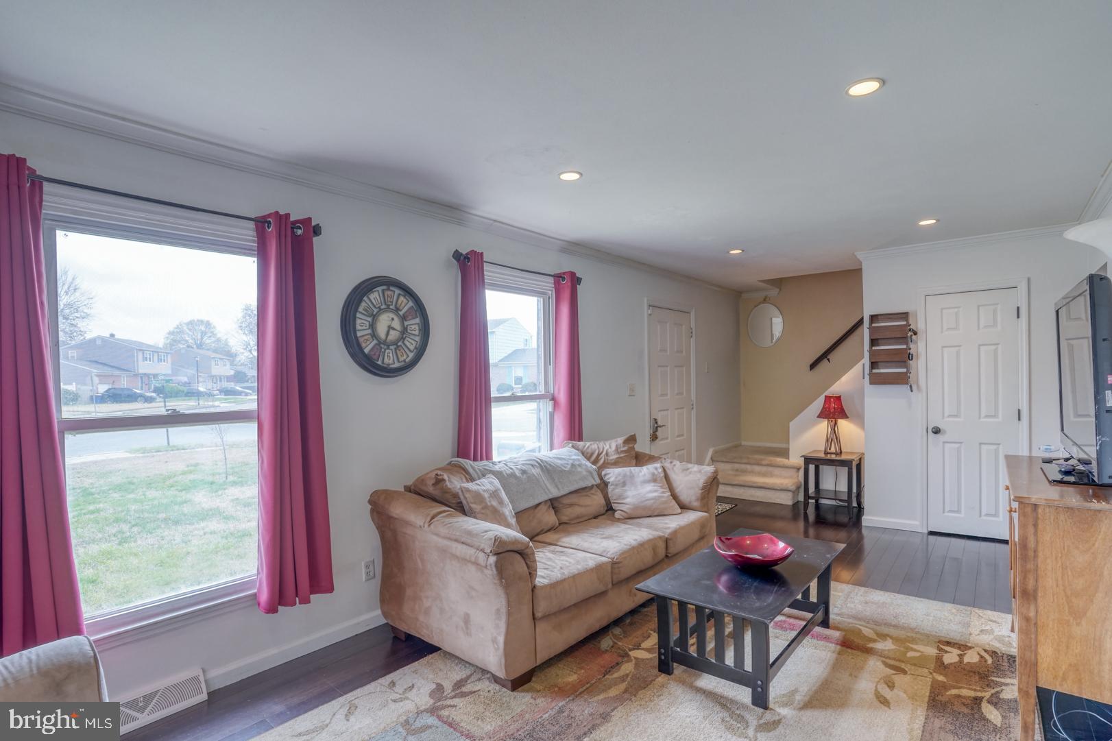 1245 Harrison Drive Dover, DE 19901 - Photo 30 of 47 a living room with furniture a clock and white walls