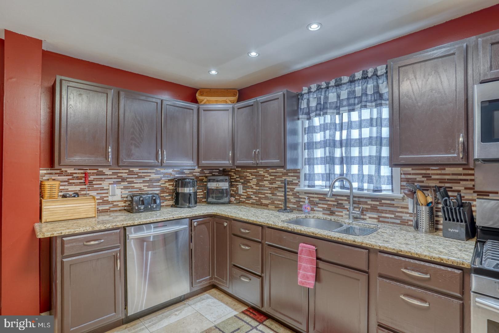 1245 Harrison Drive Dover, DE 19901 - Photo 32 of 47 a kitchen with stainless steel appliances granite countertop a sink stove and cabinets