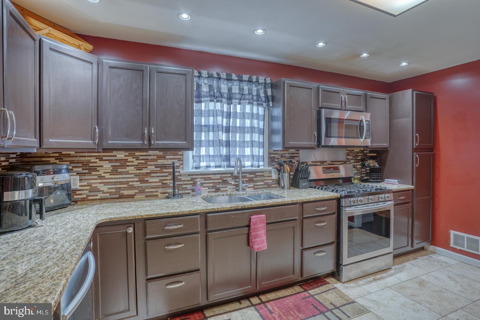 1245 Harrison Drive Dover, DE 19901 - Photo 33 of 47 a kitchen with stainless steel appliances granite countertop a stove a sink and a microwave