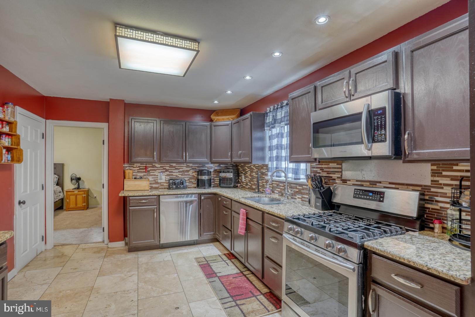 1245 Harrison Drive Dover, DE 19901 - Photo 35 of 47 a kitchen with stainless steel appliances granite countertop a stove top oven a sink and dishwasher
