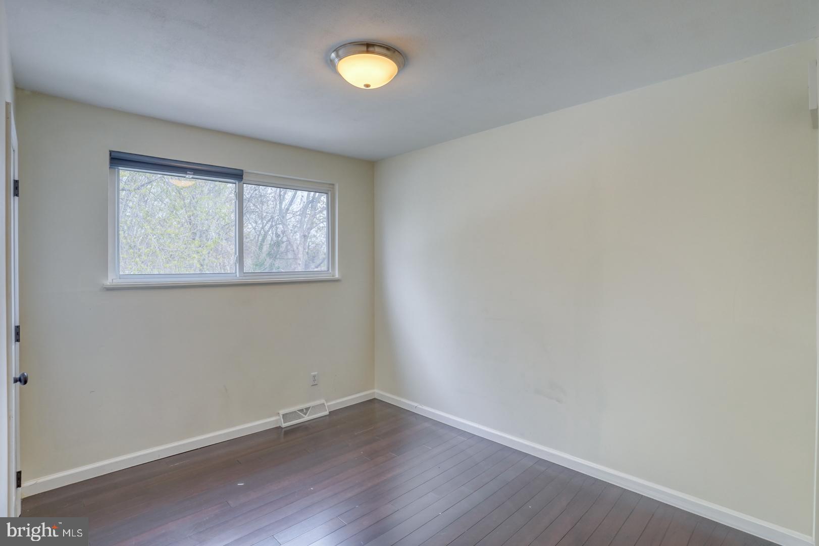 1245 Harrison Drive Dover, DE 19901 - Photo 9 of 47 an empty room with wooden floor and windows
