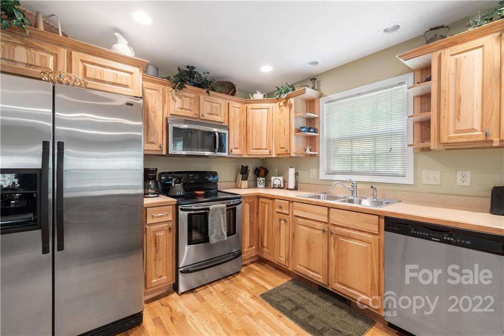 204 Nottingham Road Maggie Valley, NC 28751 - Photo 16 of 46 a kitchen with stainless steel appliances granite countertop a stove a sink and a refrigerator