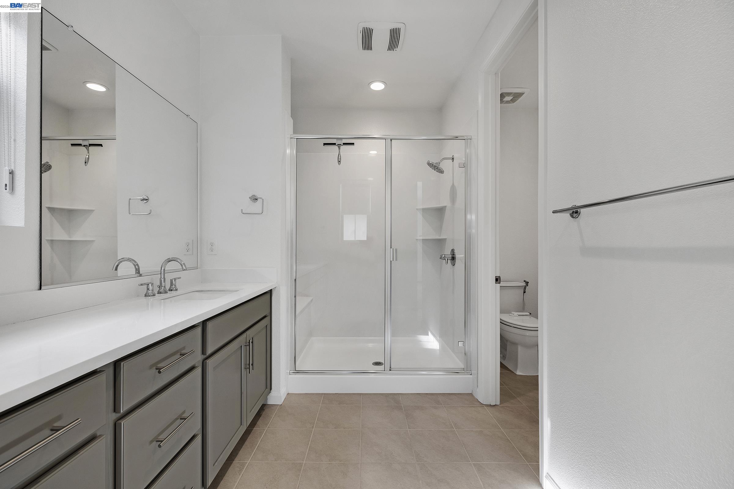 5990 Peridot Place Dublin, CA 94568 - Photo 27 of 43 a bathroom with a shower sink and mirror