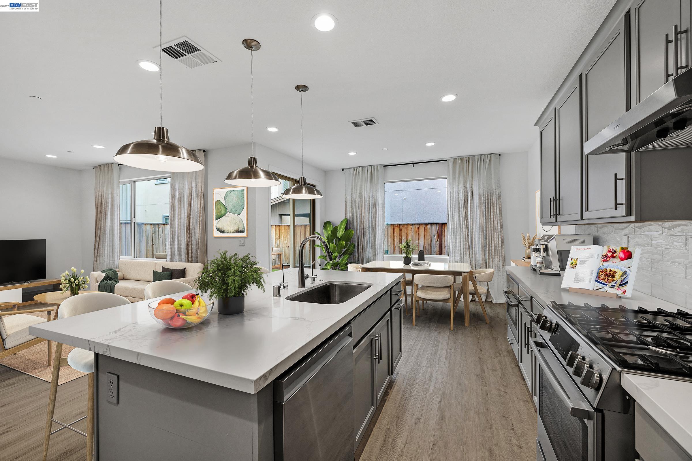 5990 Peridot Place Dublin, CA 94568 - Photo 9 of 43 a kitchen with stainless steel appliances a stove a sink a kitchen island with chairs and wooden floor