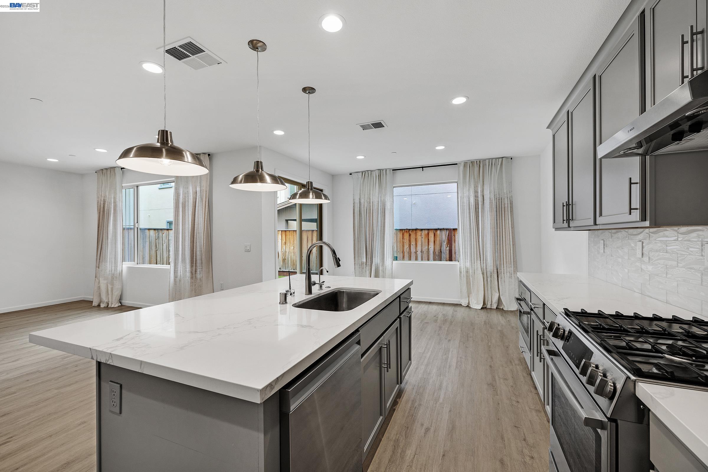 5990 Peridot Place Dublin, CA 94568 - Photo 10 of 43 a kitchen with stainless steel appliances granite countertop a sink a stove and a wooden floors