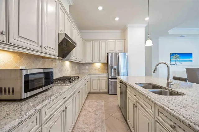 a kitchen with kitchen island granite countertop a sink stainless steel appliances and cabinets