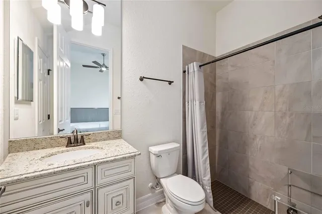 a bathroom with a granite countertop sink toilet and shower