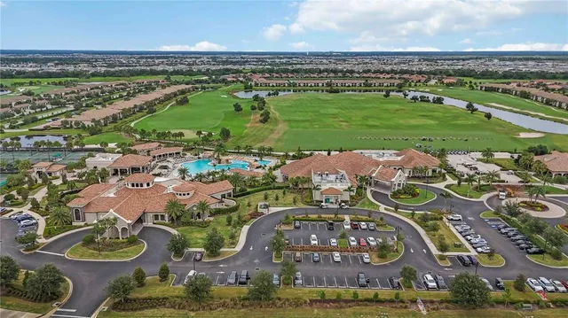 an aerial view of a residential houses with outdoor space and trees