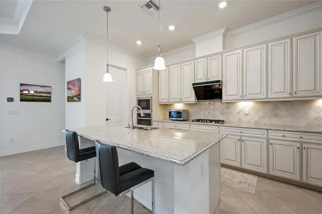 a kitchen with stainless steel appliances granite countertop a stove a sink and a refrigerator