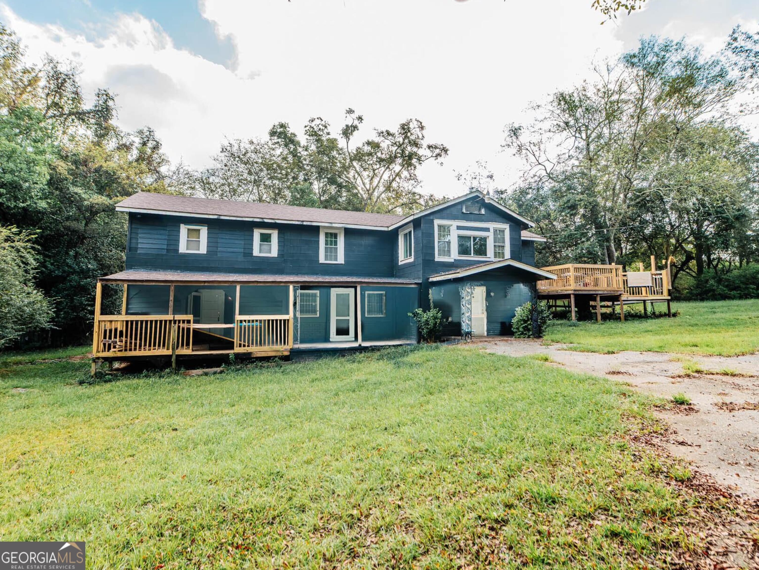a view of a house with a big yard and large trees