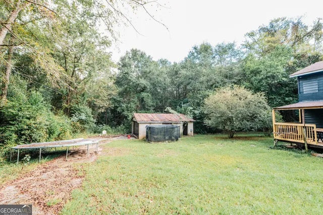 a backyard of a house with yard and trampoline