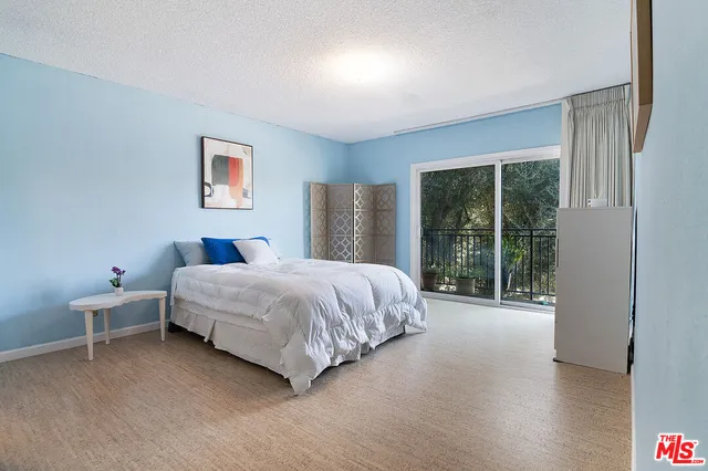 a bedroom with a bed and a painting on the wall