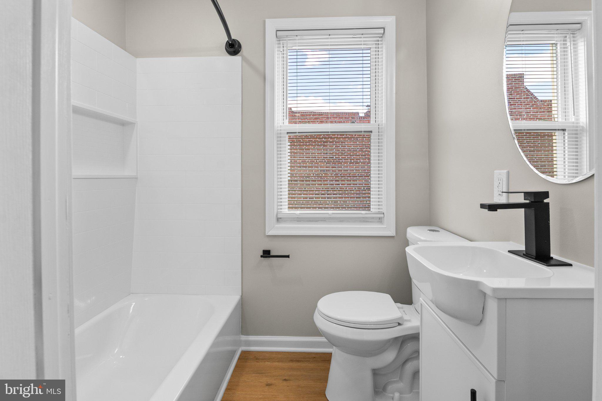 6929 Bank Street Baltimore, MD 21224 - Photo 17 of 30 a bathroom with a sink a toilet and a bathtub