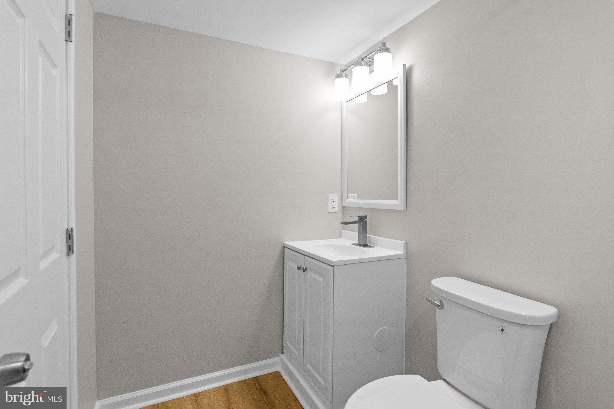 6929 Bank Street Baltimore, MD 21224 - Photo 24 of 30 a bathroom with a toilet a sink and mirror