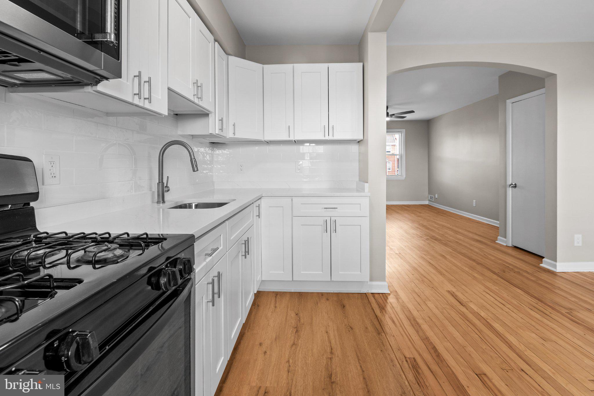 6929 Bank Street Baltimore, MD 21224 - Photo 3 of 30 a kitchen with wooden floors and appliances