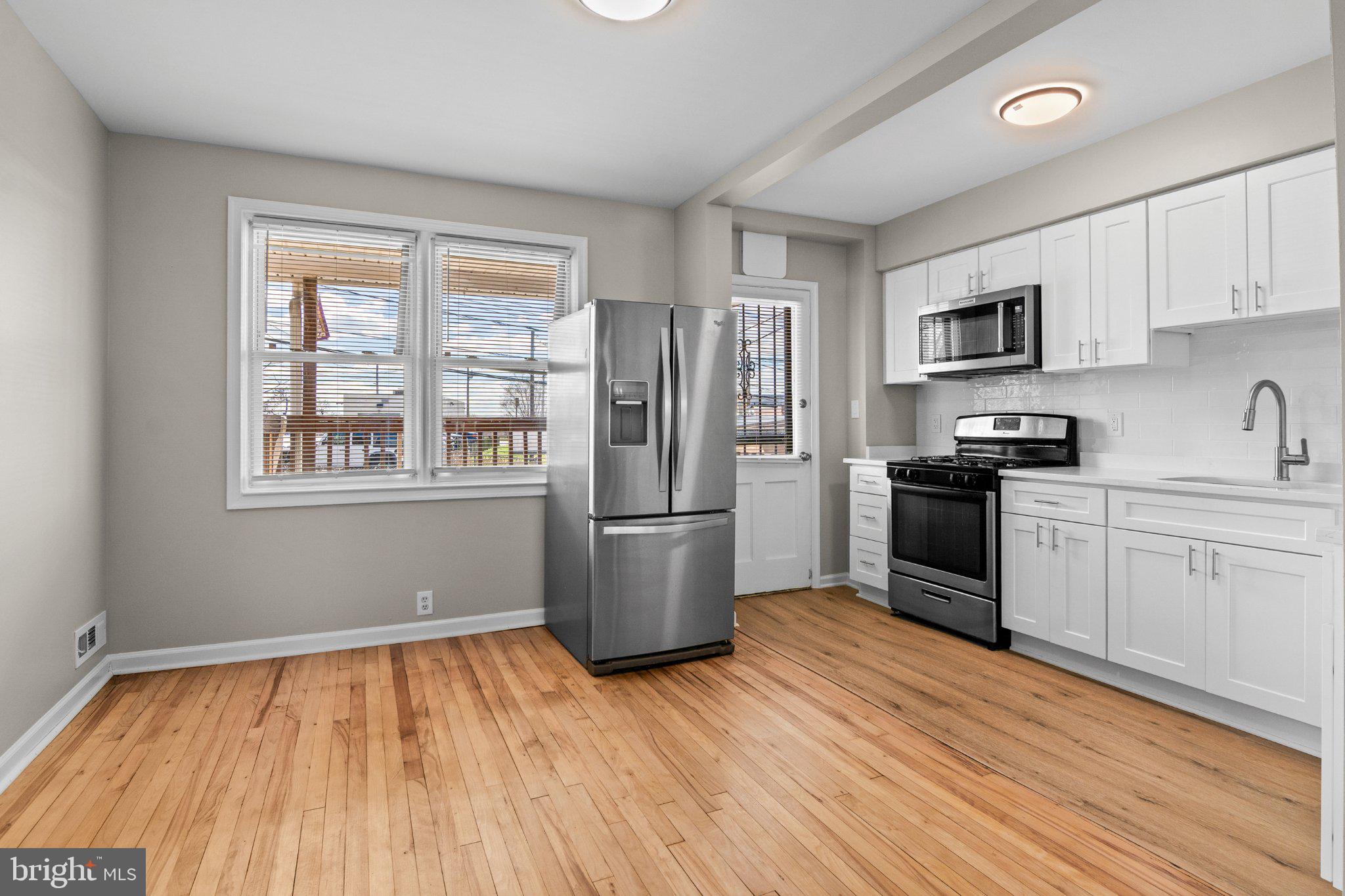 6929 Bank Street Baltimore, MD 21224 - Photo 6 of 30 a kitchen with stainless steel appliances a refrigerator stove top oven and sink