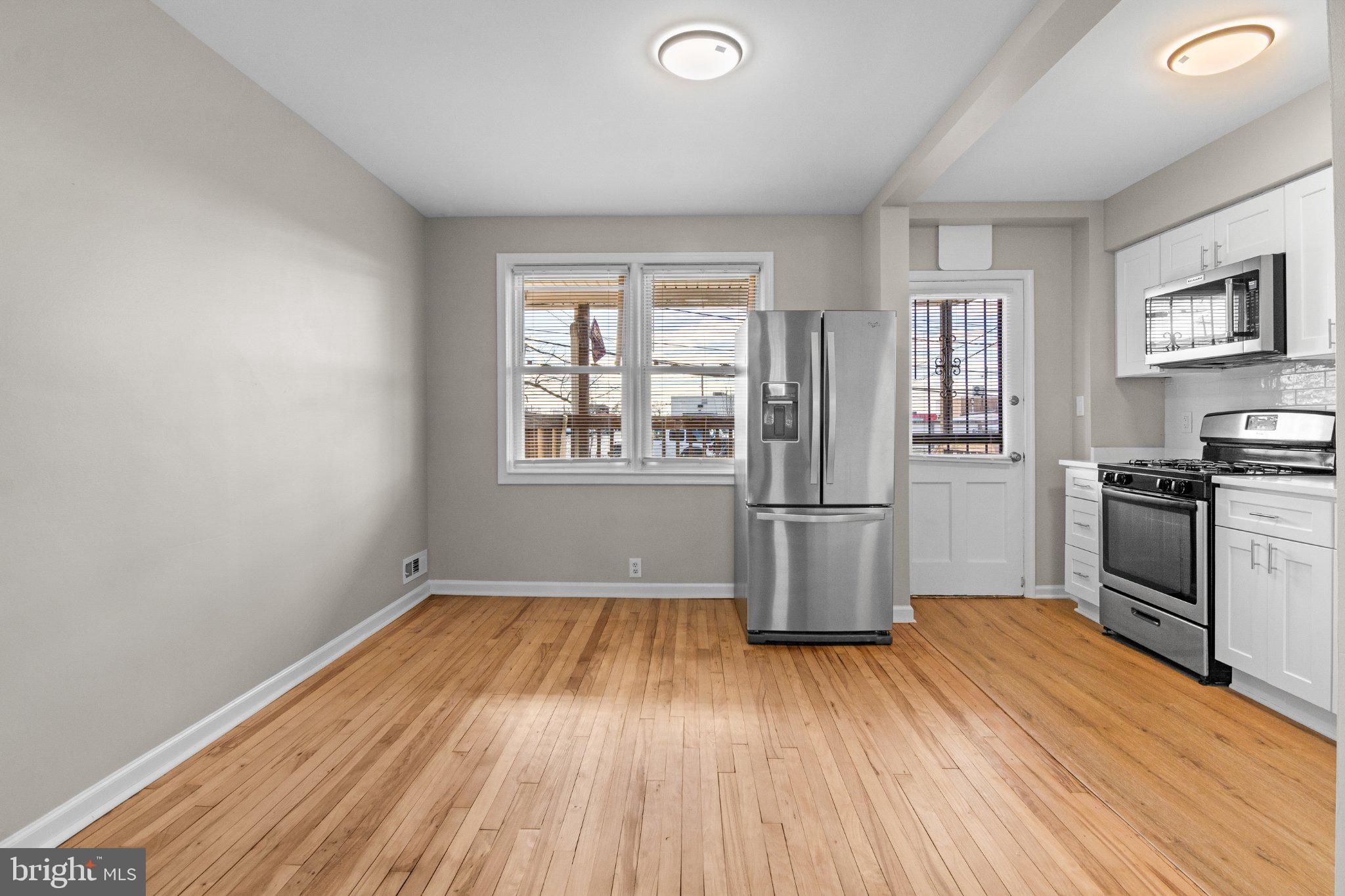 6929 Bank Street Baltimore, MD 21224 - Photo 7 of 30 a kitchen with stainless steel appliances a stove top oven and a refrigerator