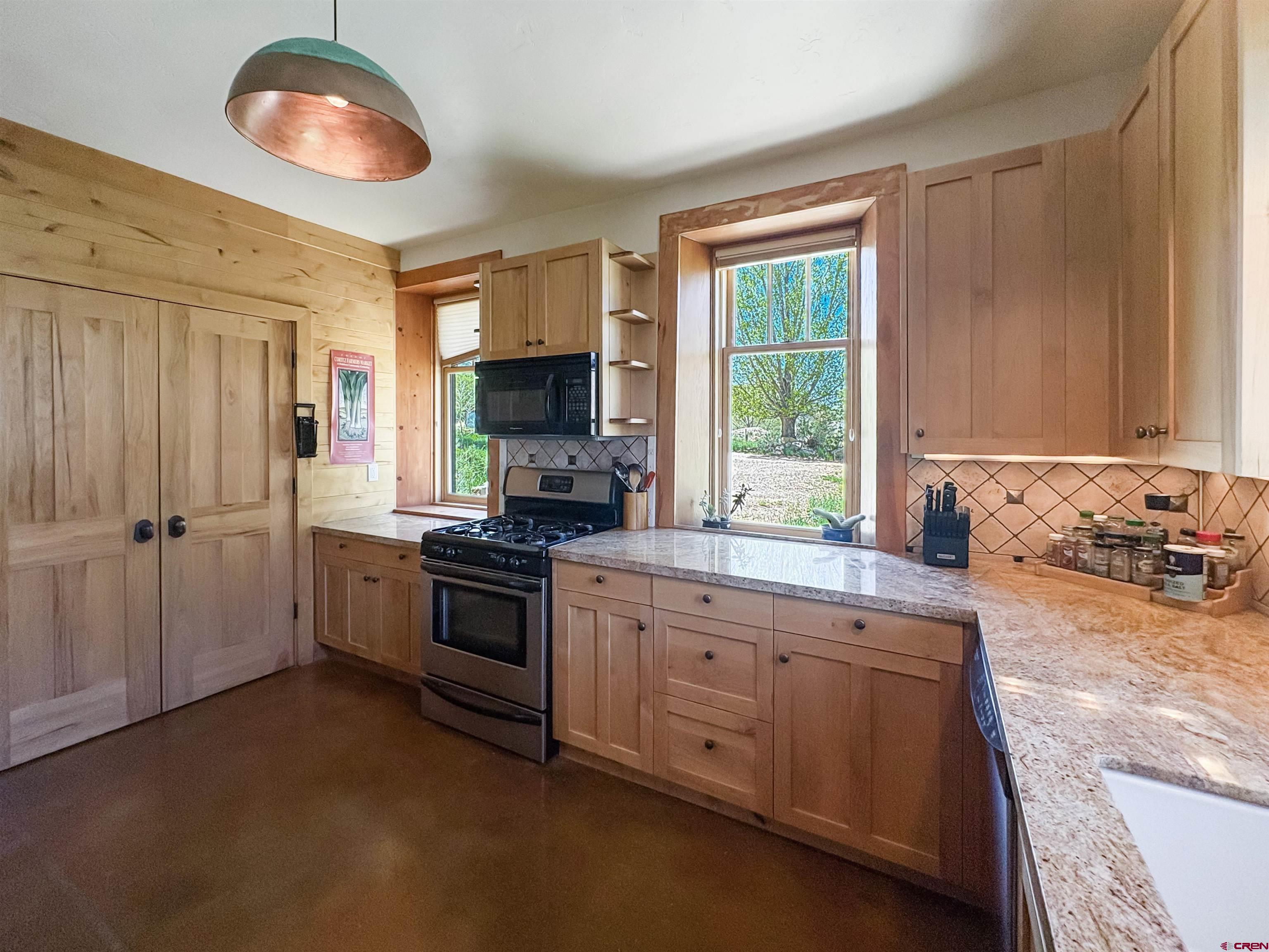 18261 Rd G Cortez, CO 81321 - Photo 11 of 44 a kitchen with stainless steel appliances granite countertop a stove sink and cabinets