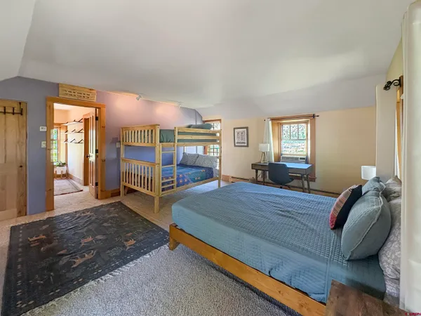 a bedroom with a bed and large windows