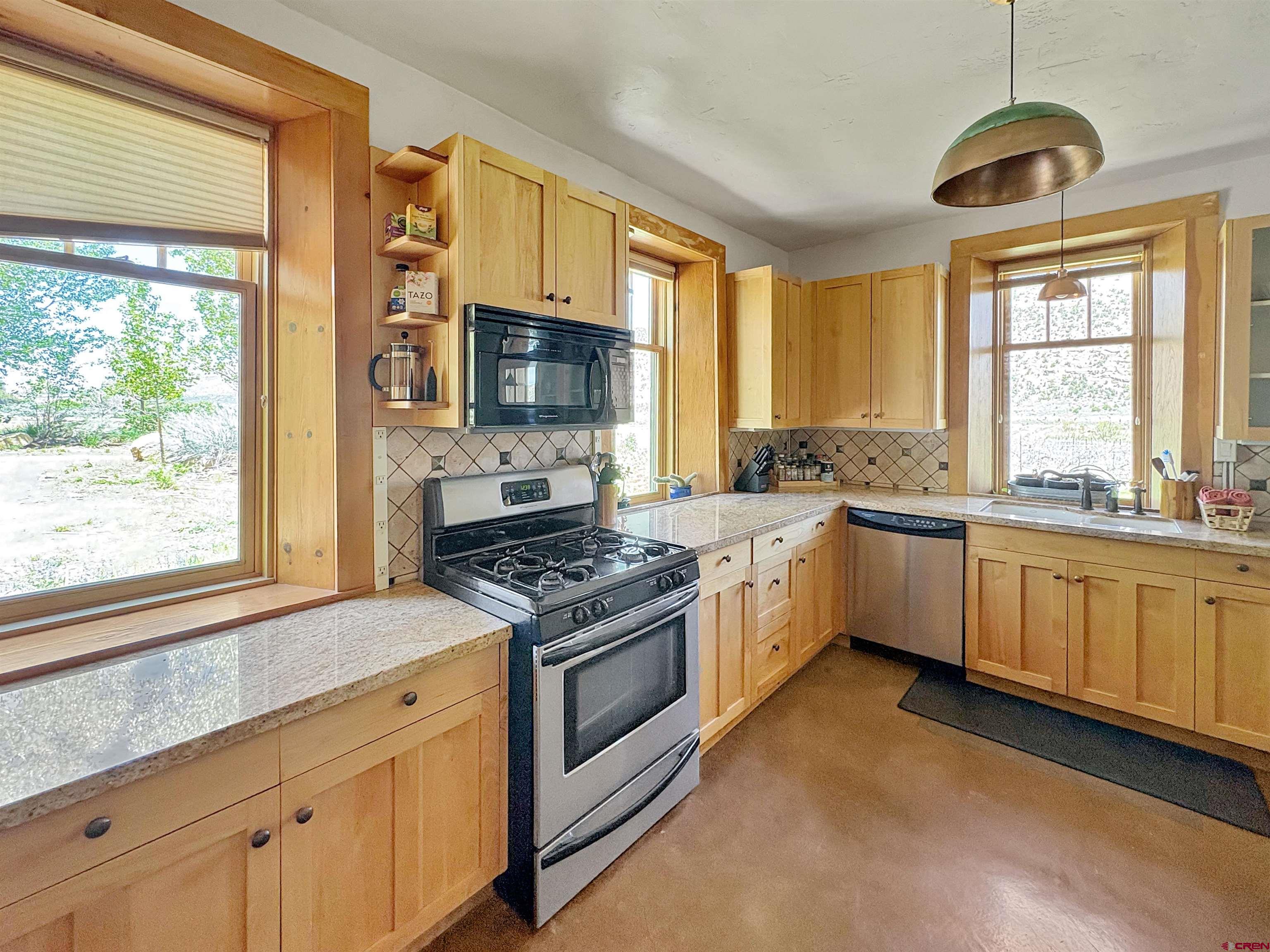 18261 Rd G Cortez, CO 81321 - Photo 8 of 44 a kitchen with stainless steel appliances granite countertop a stove a sink and a microwave