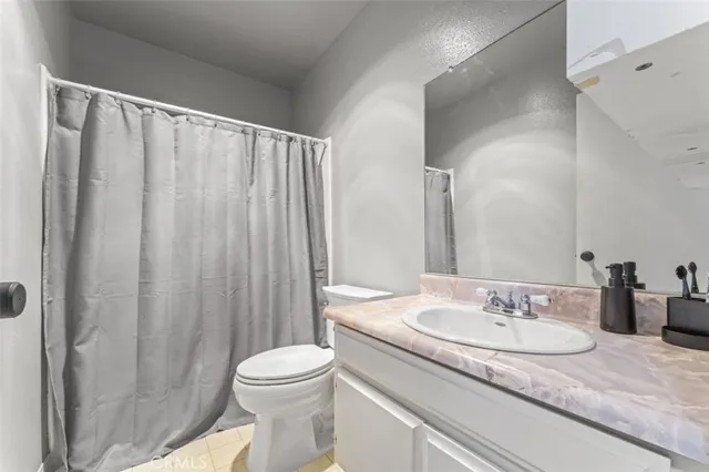 a bathroom with a granite countertop sink toilet and a mirror
