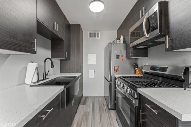 a kitchen with stainless steel appliances a sink stove and cabinets