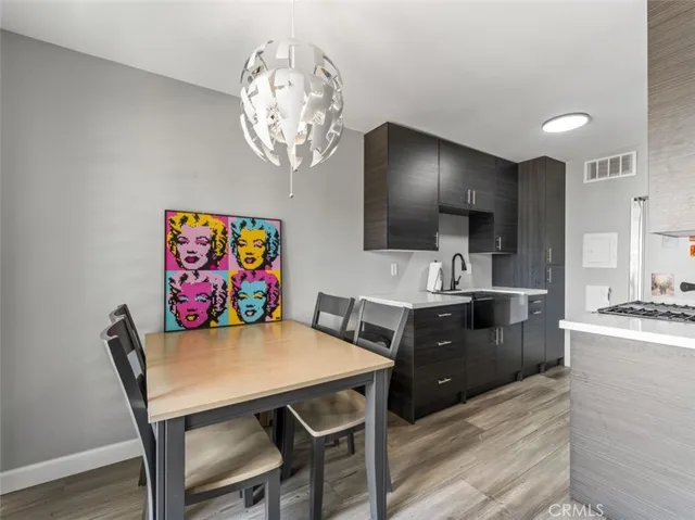 a view of a dining room with furniture a chandelier and wooden floor