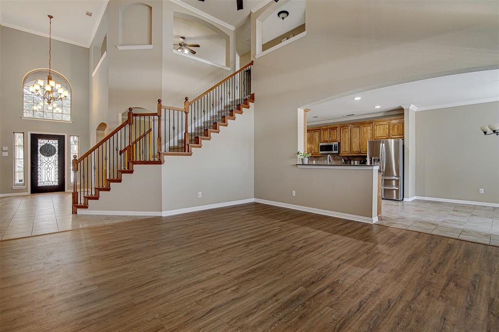 328 Tioga Street Burleson, TX 76028 - Photo 3 of 29 a view of a hallway with wooden floor and a kitchen