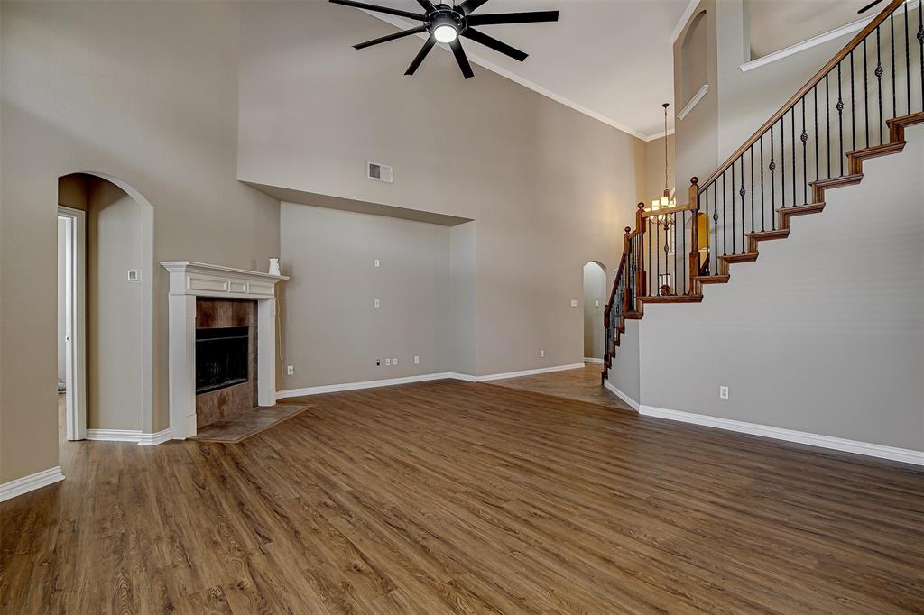 328 Tioga Street Burleson, TX 76028 - Photo 4 of 29 a view of a livingroom with wooden floor a ceiling fan and kitchen space