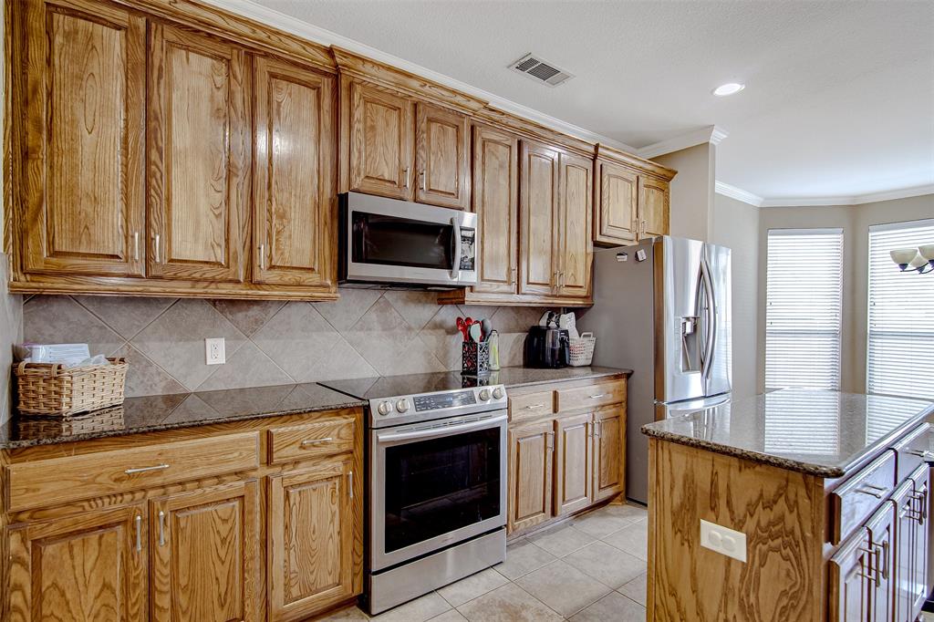 328 Tioga Street Burleson, TX 76028 - Photo 8 of 29 a kitchen with stainless steel appliances granite countertop a refrigerator stove microwave and sink