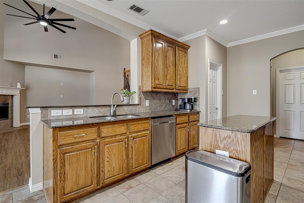 328 Tioga Street Burleson, TX 76028 - Photo 9 of 29 a kitchen with stainless steel appliances granite countertop a sink stove and cabinets