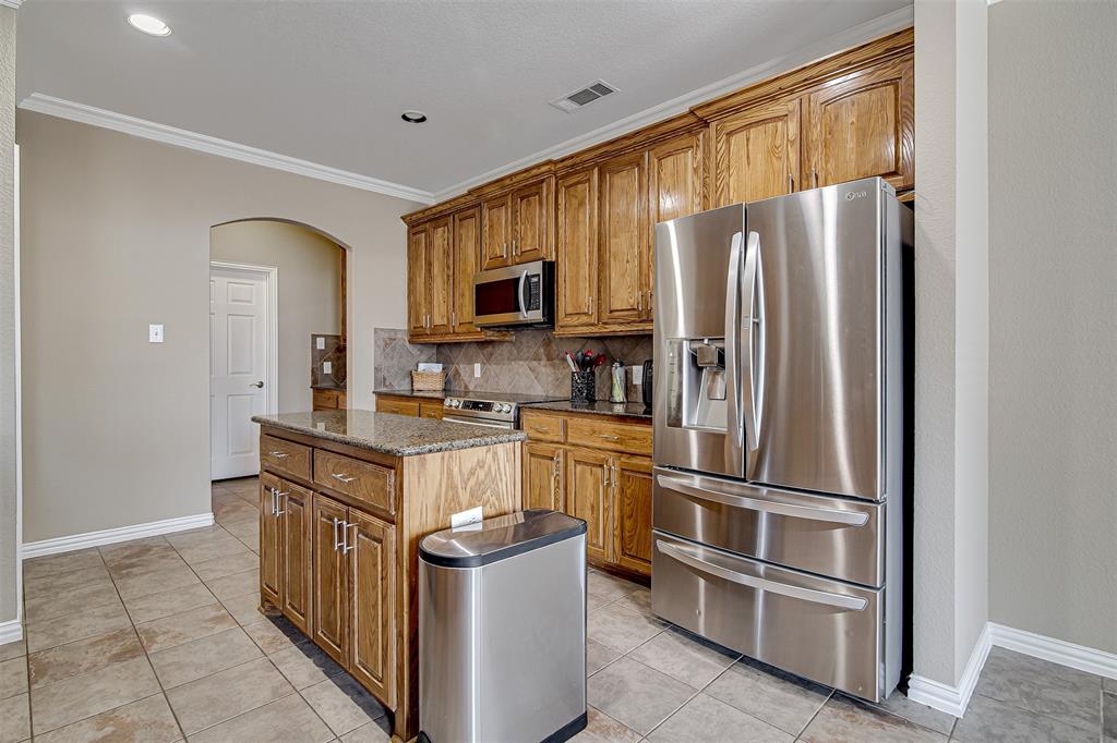 328 Tioga Street Burleson, TX 76028 - Photo 10 of 29 a kitchen with stainless steel appliances granite countertop a refrigerator stove and microwave