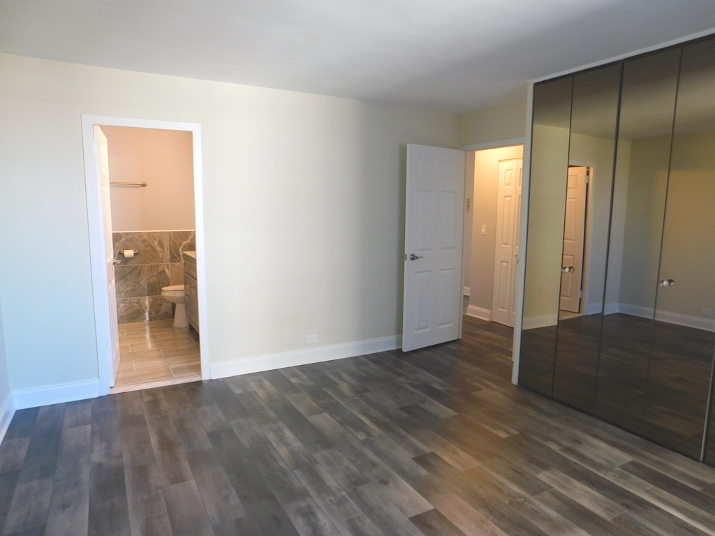 5701 North Sheridan Road, Unit 12L Chicago, IL 60660 - Photo 20 of 42 an empty room with wooden floor and mirror