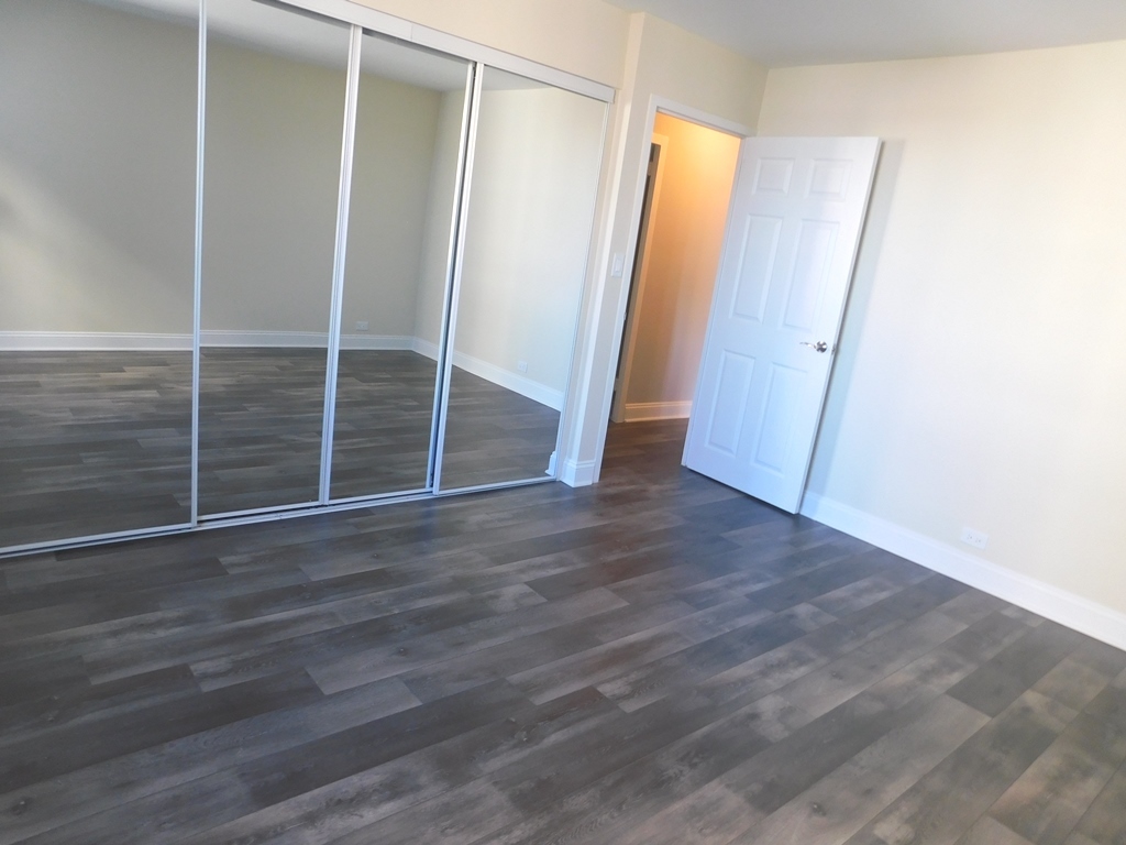 5701 North Sheridan Road, Unit 12L Chicago, IL 60660 - Photo 21 of 42 an empty room with wooden floor and sliding door