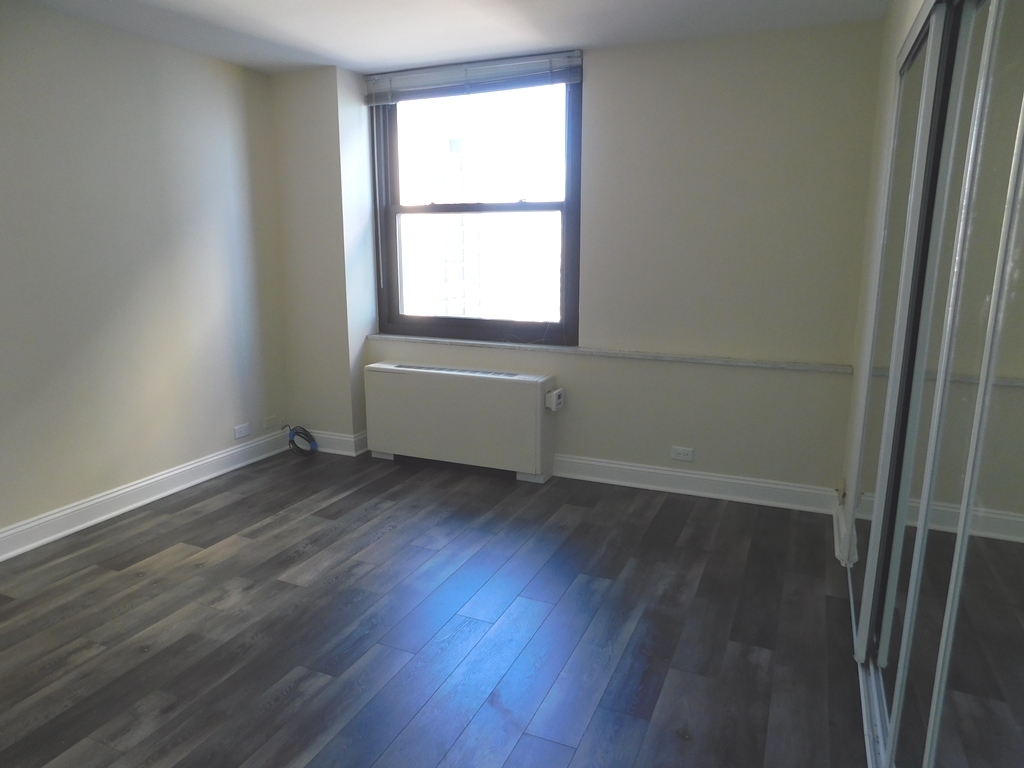 5701 North Sheridan Road, Unit 12L Chicago, IL 60660 - Photo 24 of 42 an empty room with wooden floor and windows