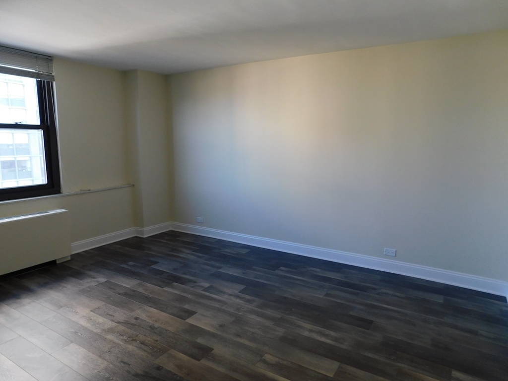 5701 North Sheridan Road, Unit 12L Chicago, IL 60660 - Photo 26 of 42 an empty room with wooden floor and windows