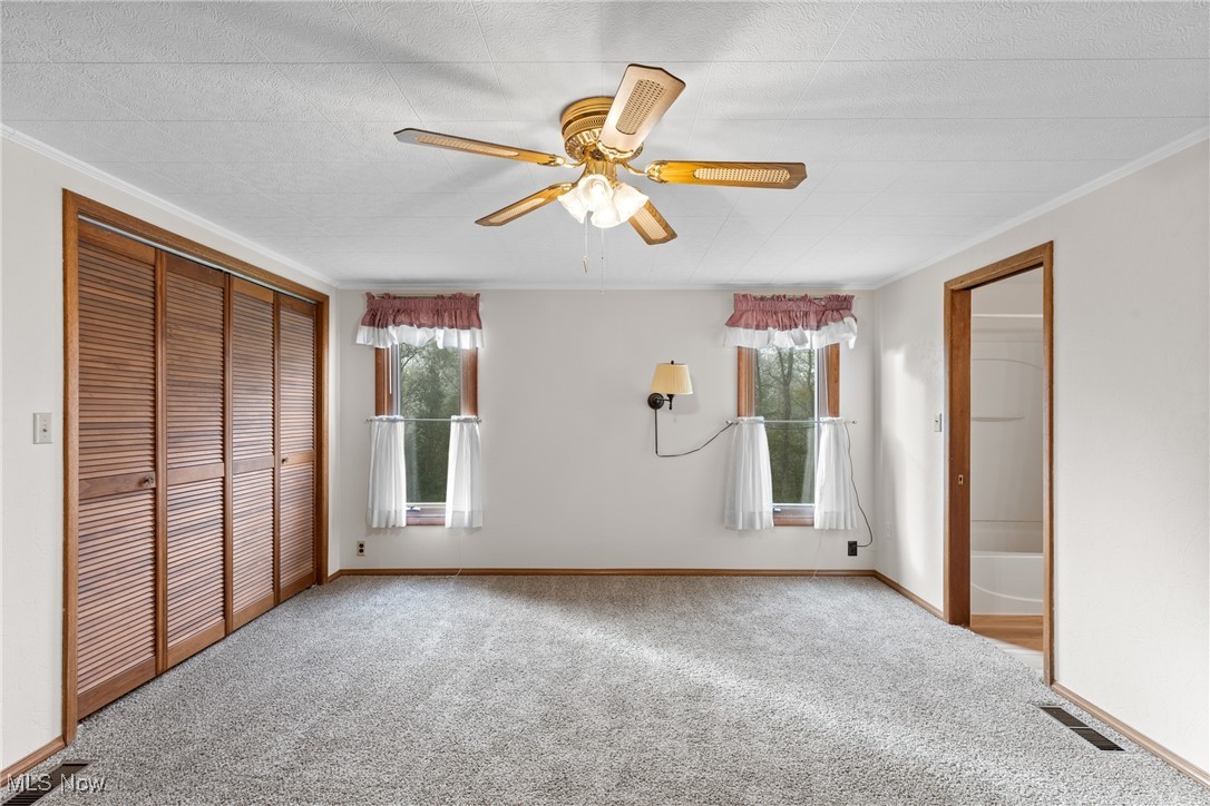 59638 Broadview Road Shadyside, OH 43947 - Photo 17 of 43 Unfurnished bedroom with a closet, carpet floors, ceiling fan, and crown molding