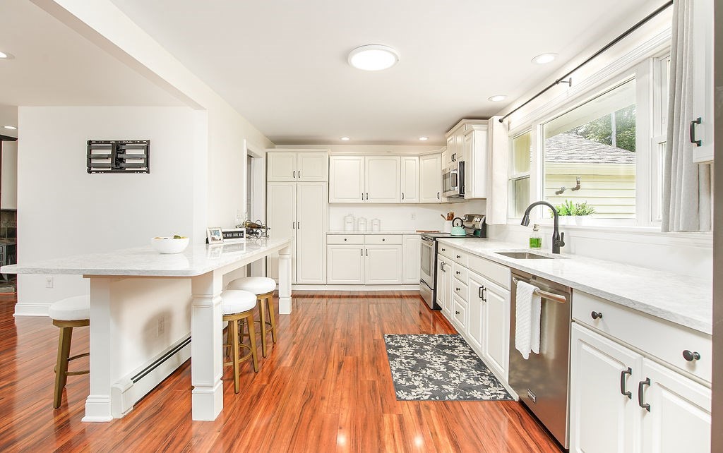 84 Clark Road Sturbridge, MA 01518 - Photo 3 of 30 a kitchen with wooden floors and white cabinets