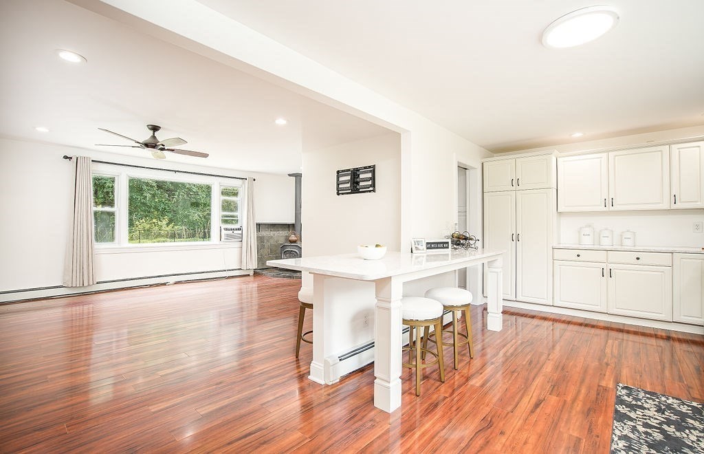 84 Clark Road Sturbridge, MA 01518 - Photo 8 of 30 a view of kitchen with stainless steel appliances granite countertop a stove top oven a sink dishwasher and white cabinets with wooden floor next to windows