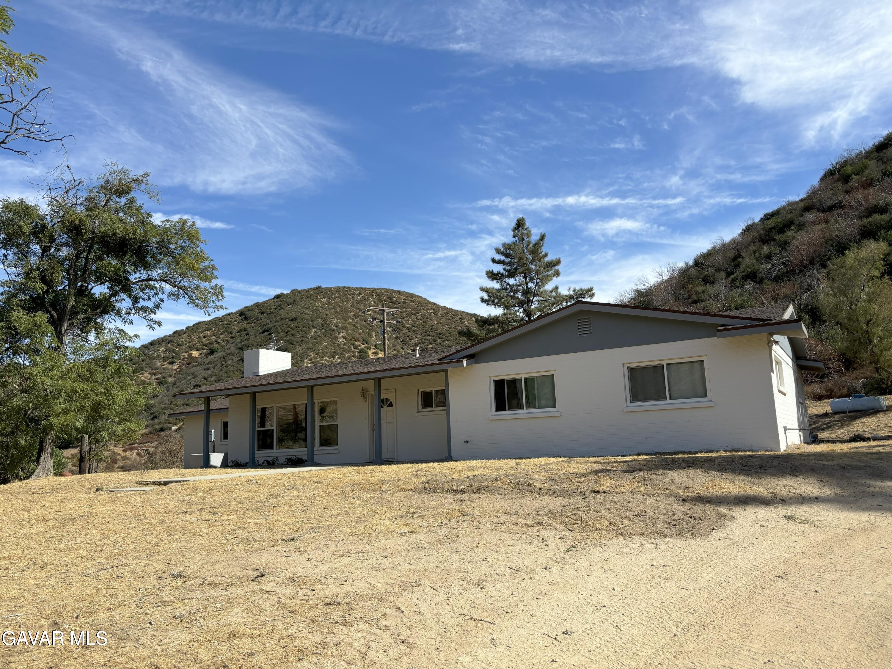 42930 Lake Hughes Road Lake Hughes, CA 93532 - Photo 4 of 38 a front view of house with yard and trees in the background