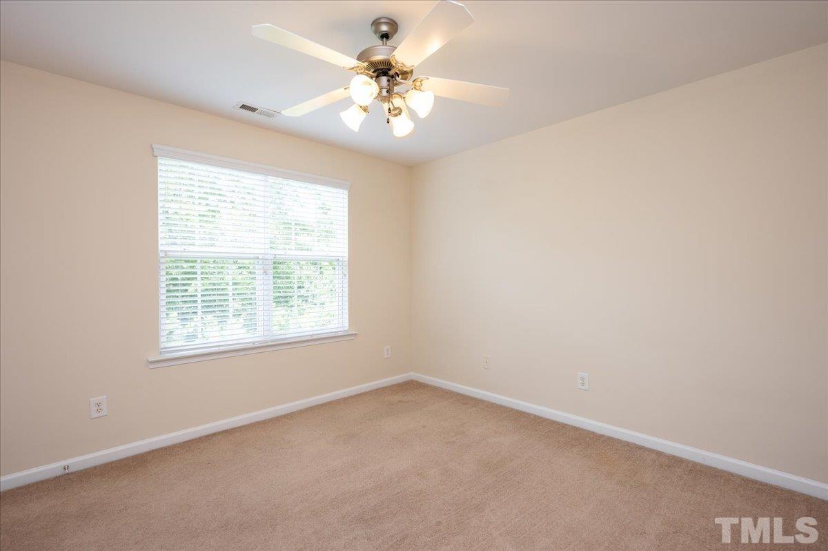 160 Grey Elm Trail Durham, NC 27713 - Photo 17 of 25 an empty room with a chandelier fan and windows