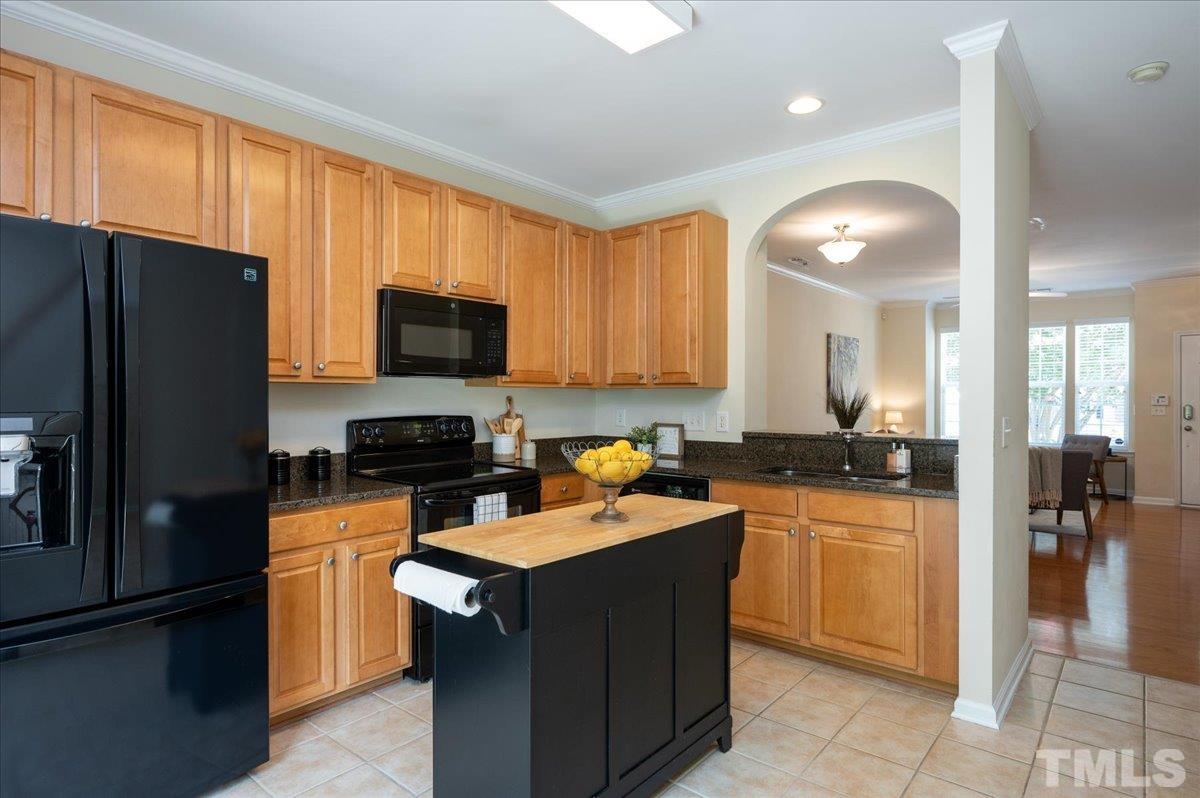 160 Grey Elm Trail Durham, NC 27713 - Photo 4 of 25 a kitchen with a refrigerator a stove top oven a sink dishwasher and wooden cabinets