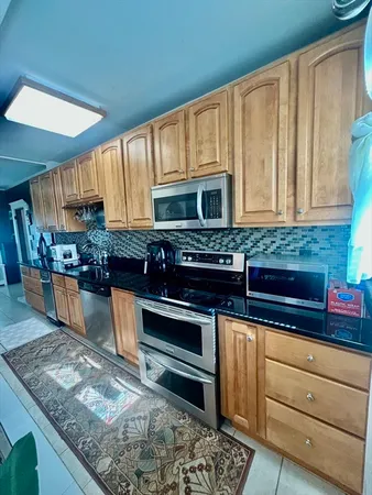 a kitchen with stainless steel appliances granite countertop a sink and a stove