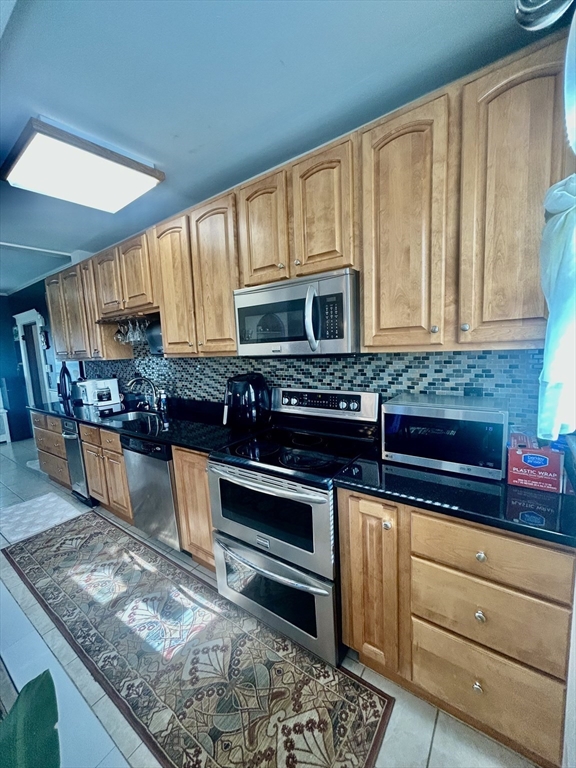 114 Lovell Street Worcester, MA 01603 - Photo 12 of 39 a kitchen with stainless steel appliances granite countertop a stove a sink and a microwave
