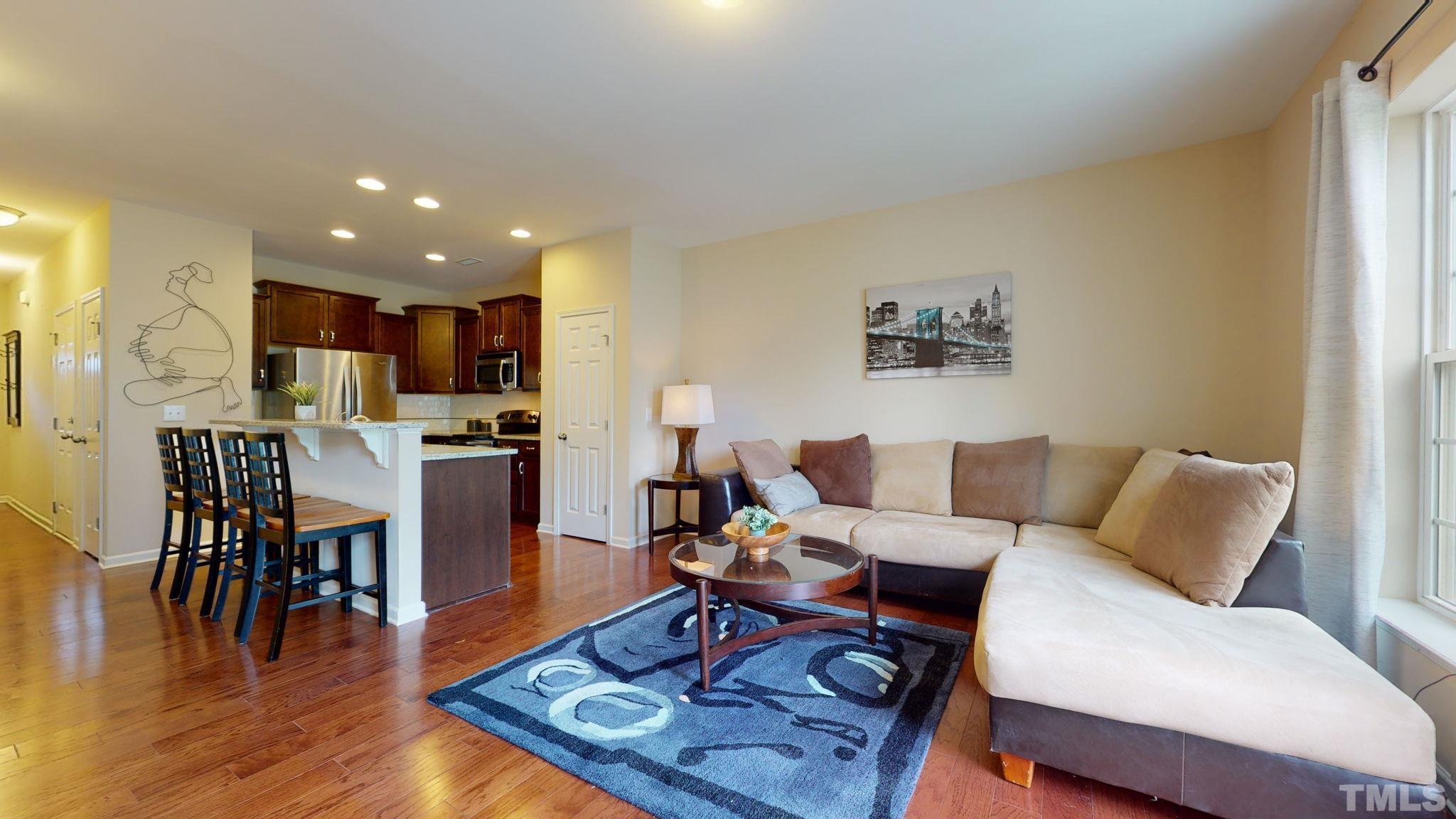 944 Consortium Drive Raleigh, NC 27603 - Photo 12 of 30 a living room with furniture and kitchen view with wooden floor